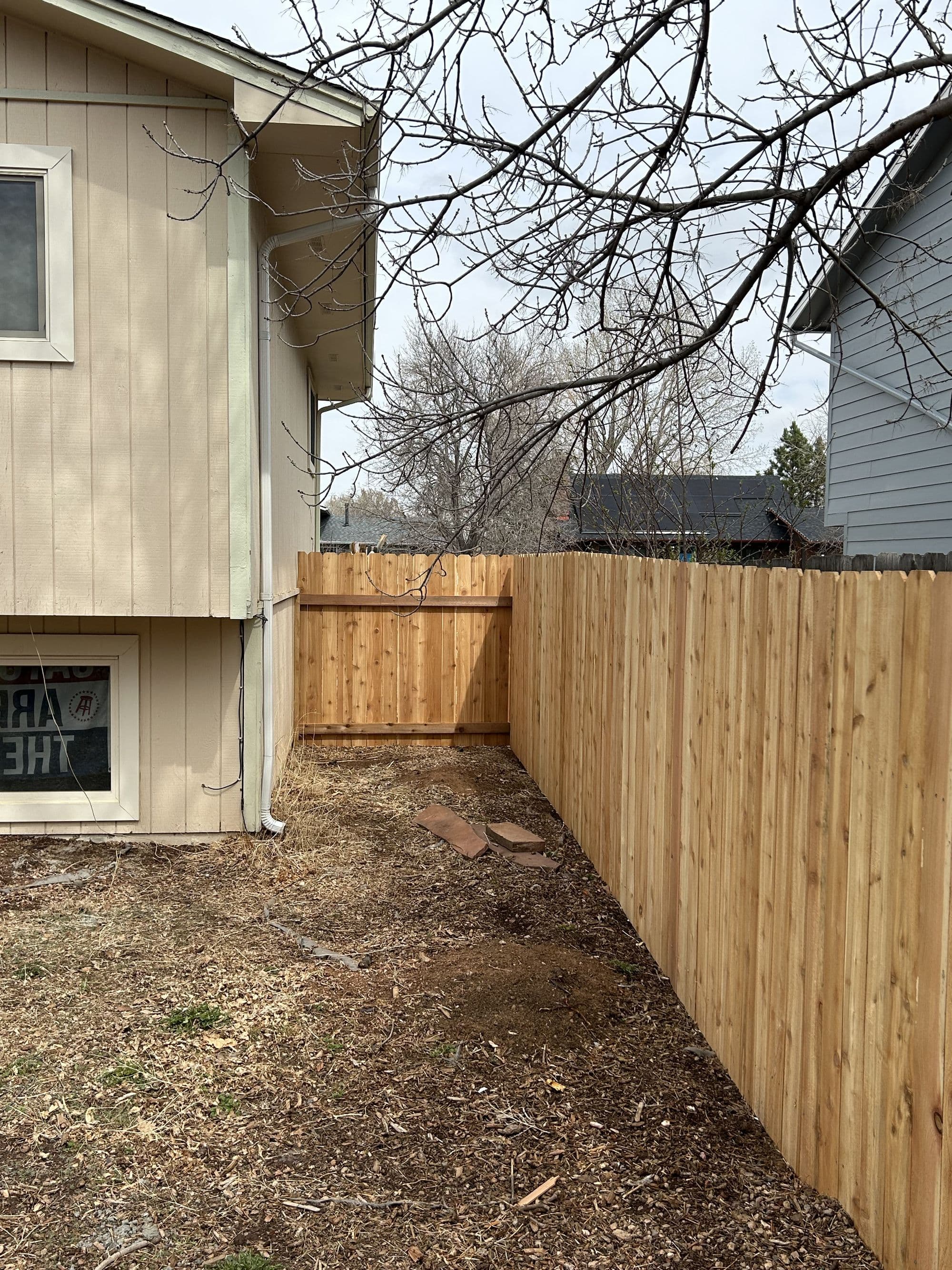 New wood fence corner along a home's side yard