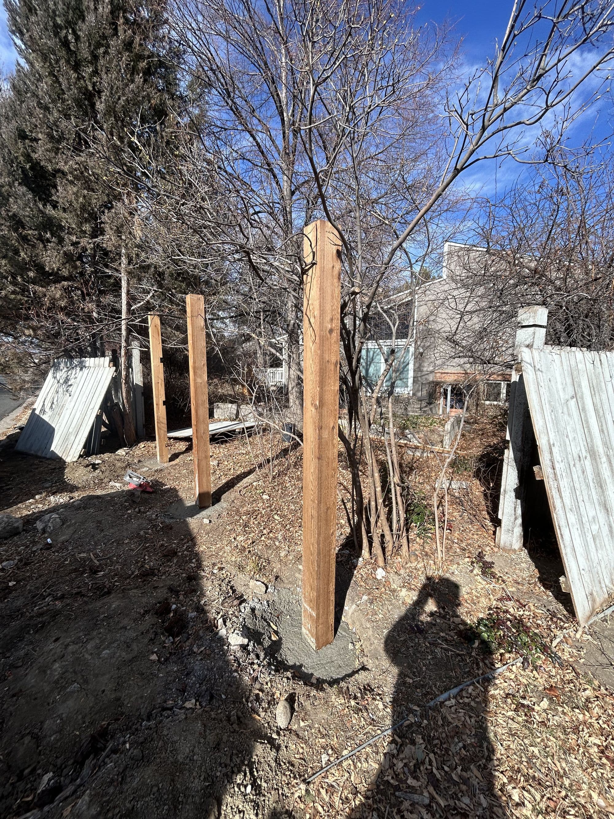 Installing new fence posts during a fence repair project