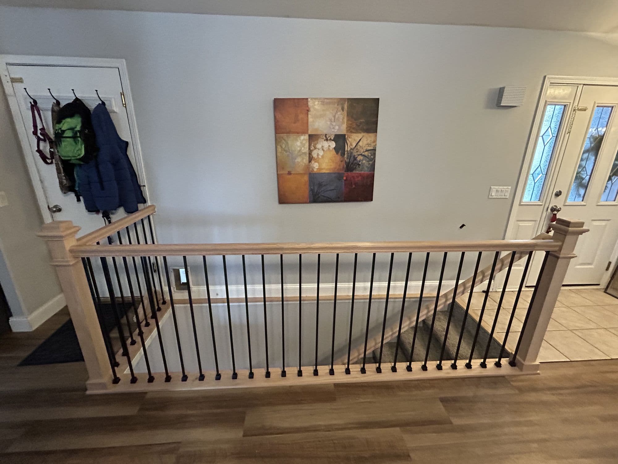 Finished interior stair railing with black metal balusters