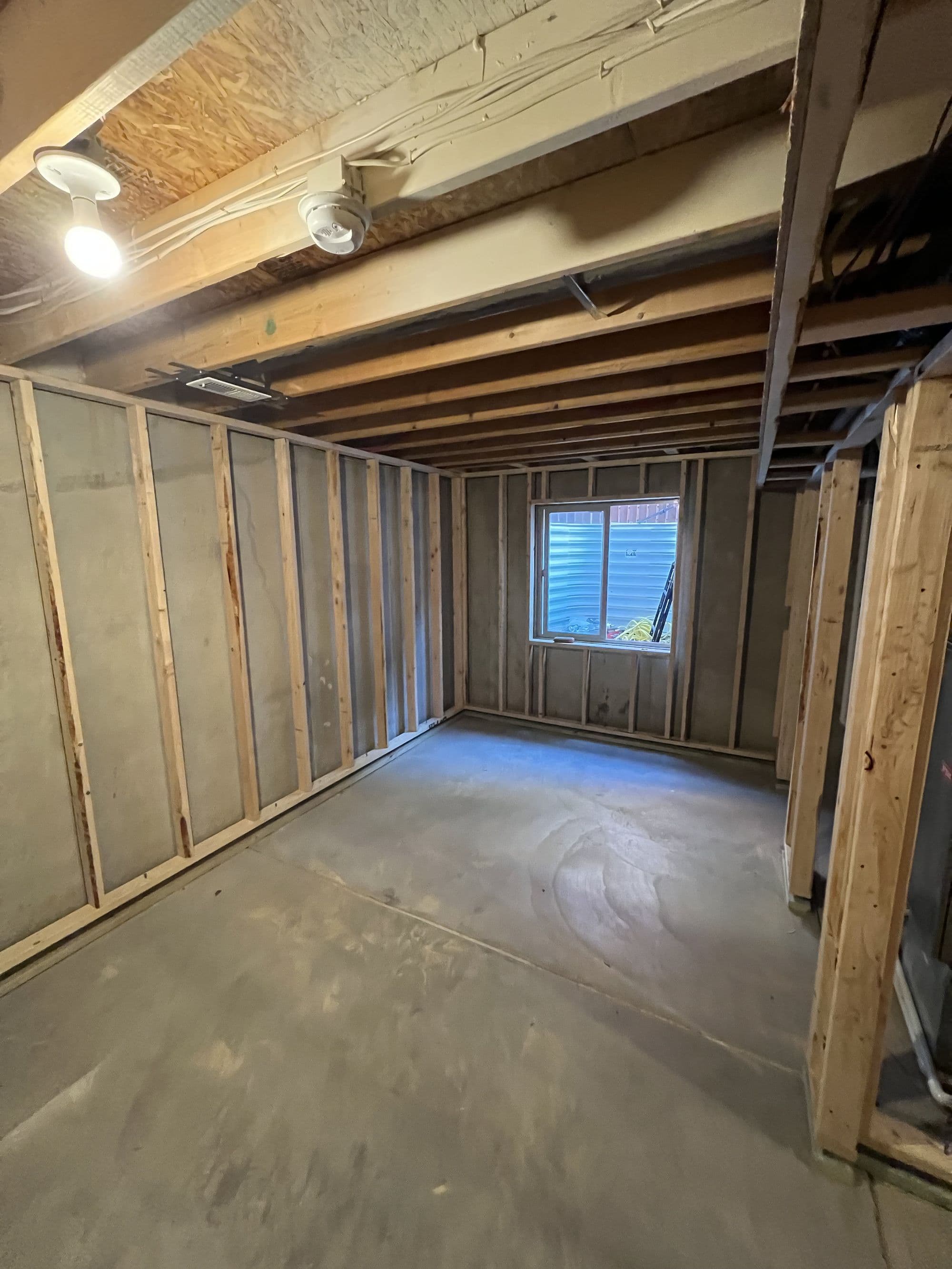 Framed basement room with window during finishing