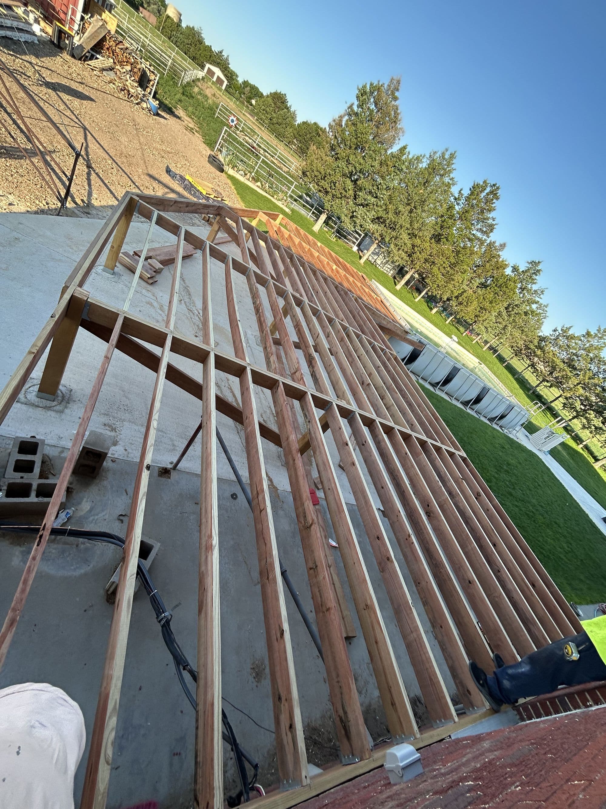 Deck framing underway around an above-ground pool