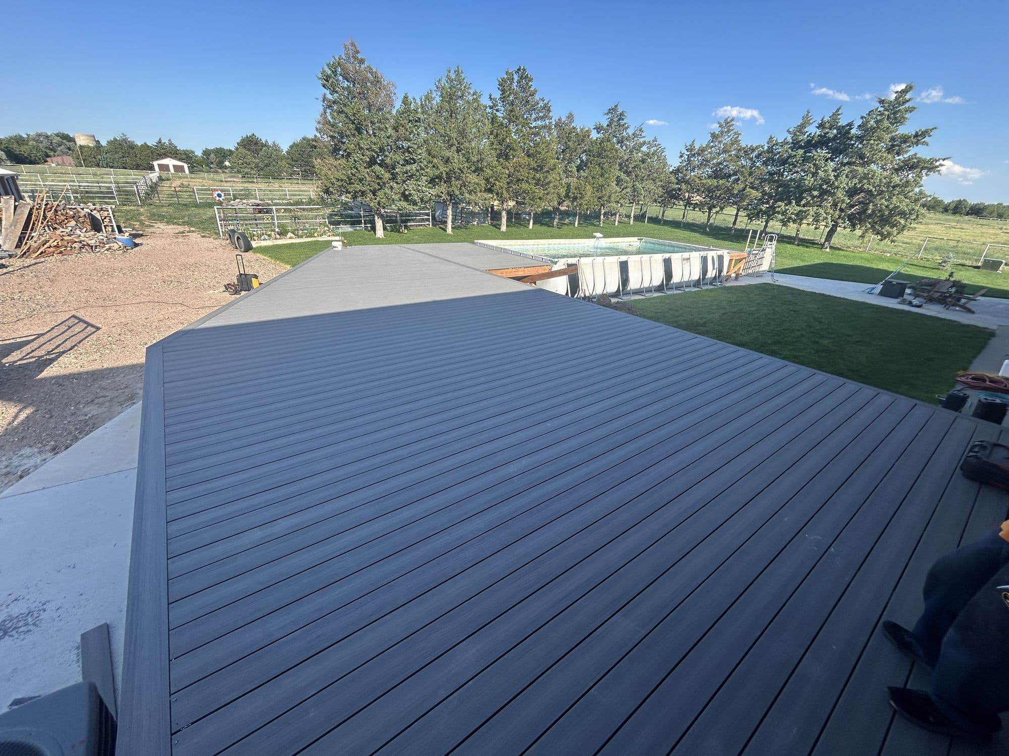Deck framing with pool visible, wide view