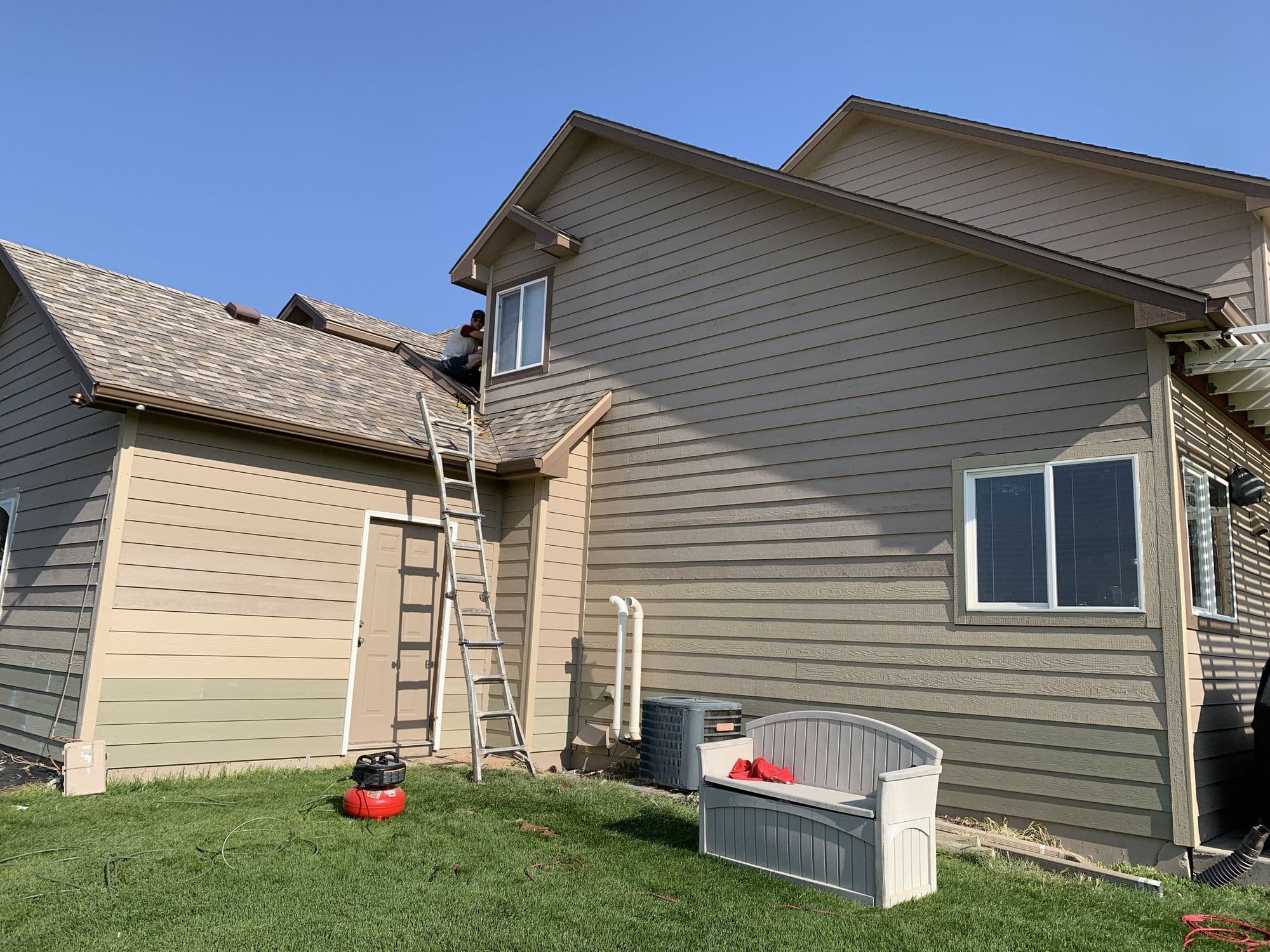 Roof and siding repair work in progress on a home exterior
